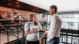 Twee collega's in gesprek in een moderne kantoorruimte