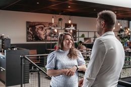 Twee collega's in gesprek in een moderne kantoorruimte