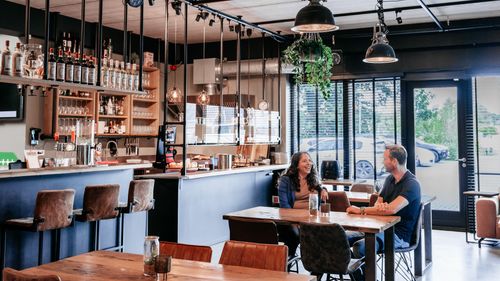 Twee collega’s van Rochewood in gesprek aan een tafel in de lunchruimte