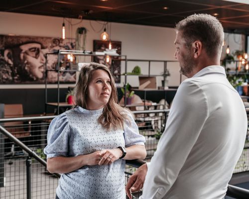 Twee collega's in gesprek in een moderne kantoorruimte