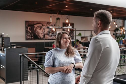 Twee collega's in gesprek in een moderne kantoorruimte