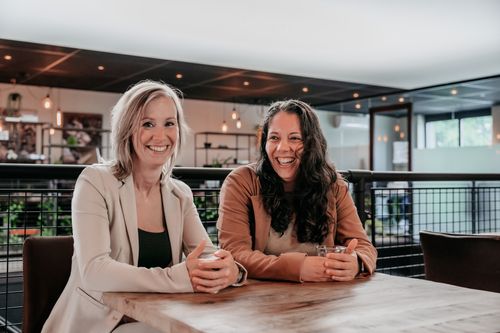 Twee collega's in gesprek in een moderne kantoorruimte