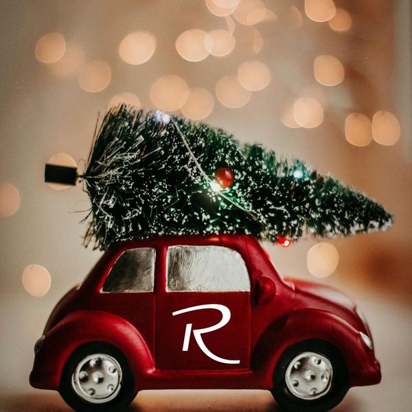 Klein rood speelgoedautootje met een kerstboom op het dak