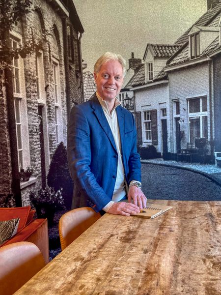Martijn van Scherpenseel - collega Acceptant bij Rochewood. Hij staat aan een hoge tafel met een opschrijfboekje