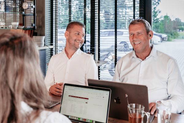 Drie collega’s van Rochewood in gesprek aan een vergadertafel