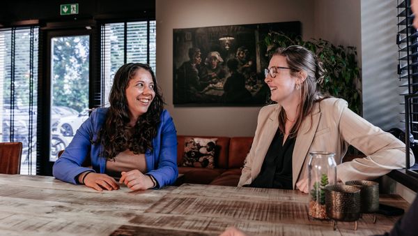 Twee collega's van Rochewood in gesprek aan een vergadertafel