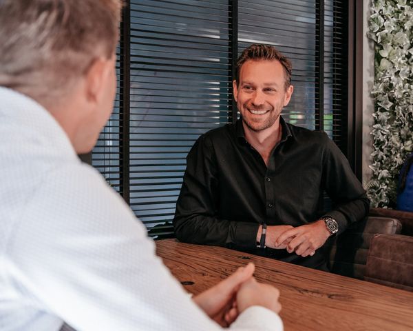 Twee collega’s van Rochewood in gesprek aan een vergadertafel