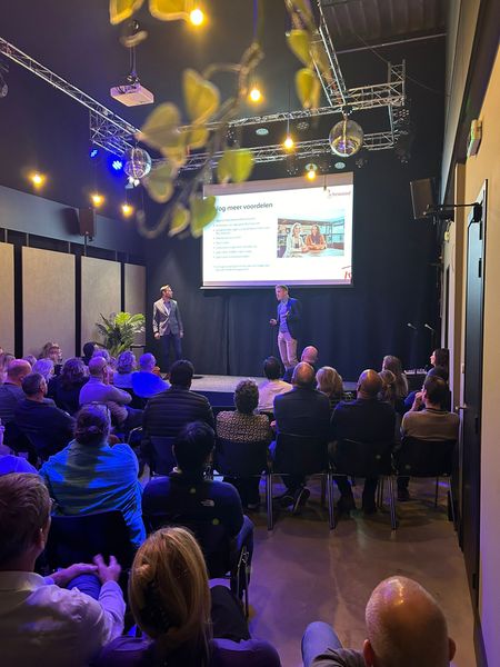 Twee sprekers geven een presentatie tijdens het Rochewood-event 'Mijn toekomst als zzp’er', voor een volle zaal met publiek