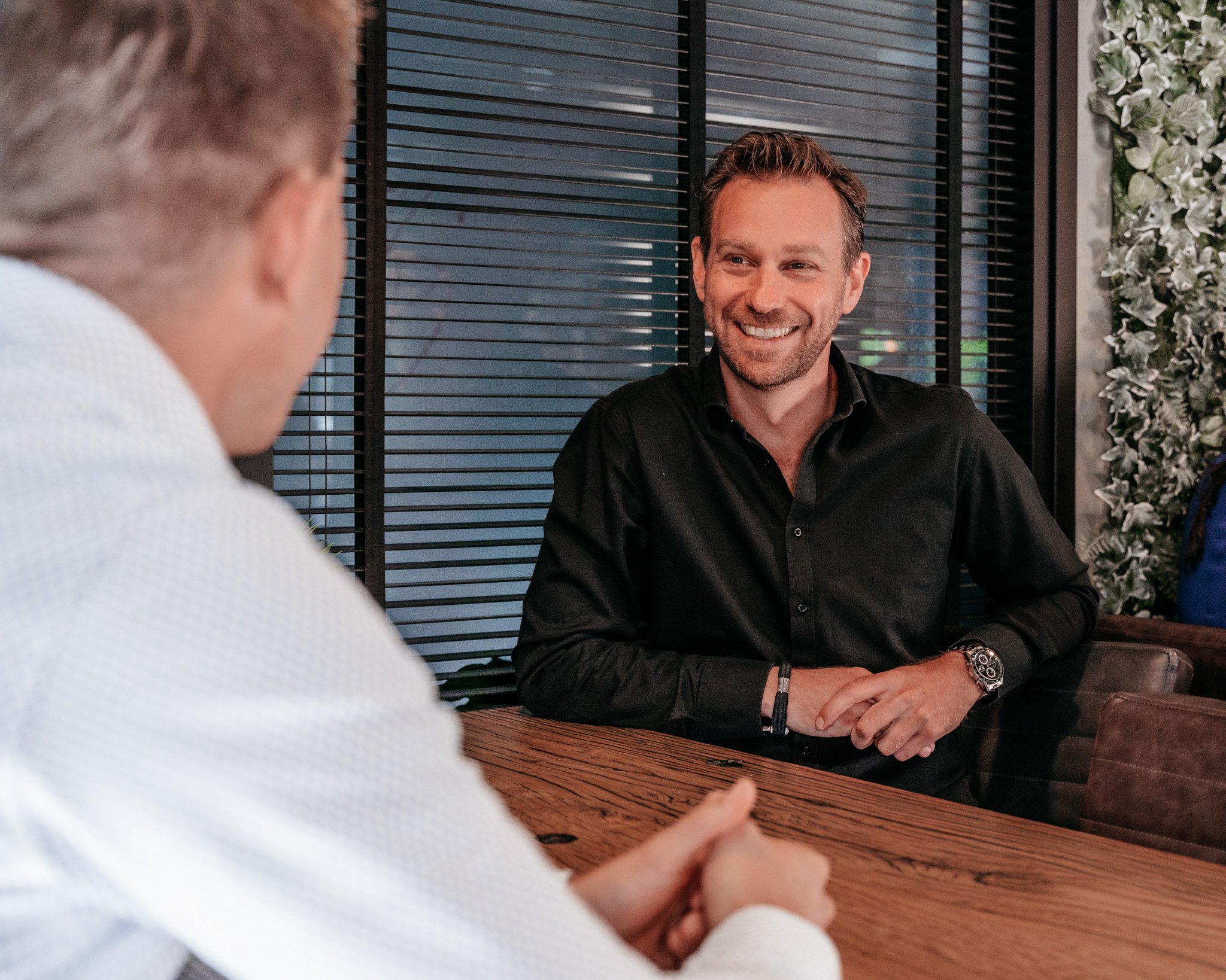 Twee collega’s van Rochewood in gesprek aan een vergadertafel