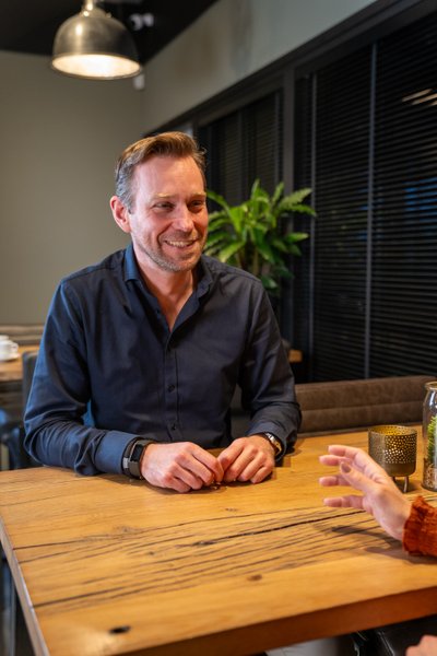 Twee collega's in gesprek aan een vergadertafel in een moderne kantoorruimte