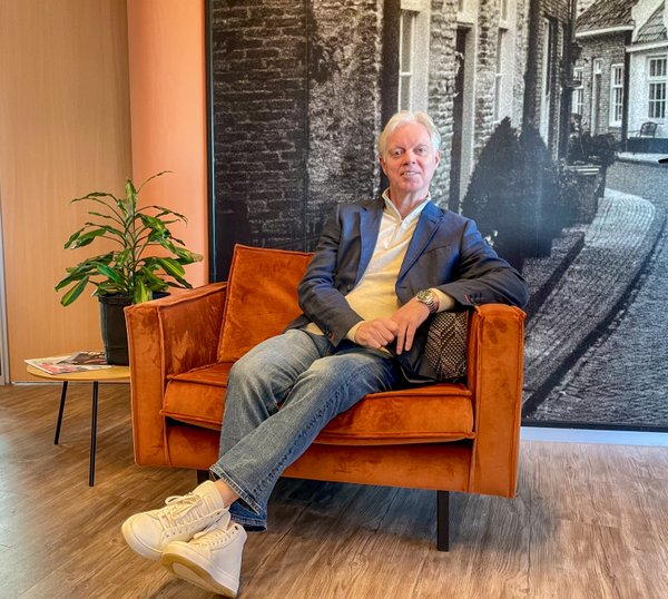 Martijn van Scherpenseel - collega Acceptant bij Rochewood. Hij zit in een oranje stoel met links een plant