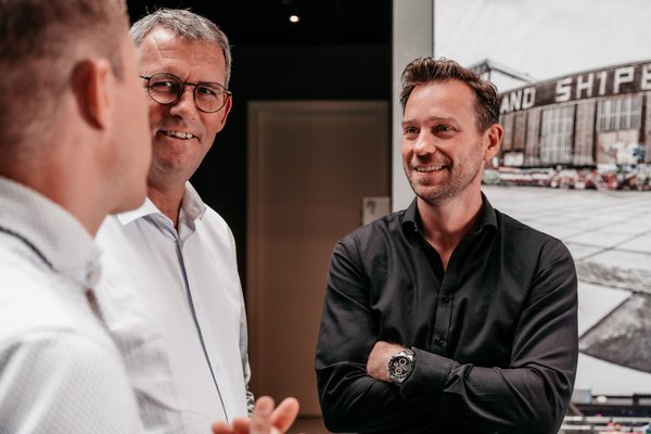 Drie collega's van Rochewood met elkaar in gesprek in een moderne kantooromgeving