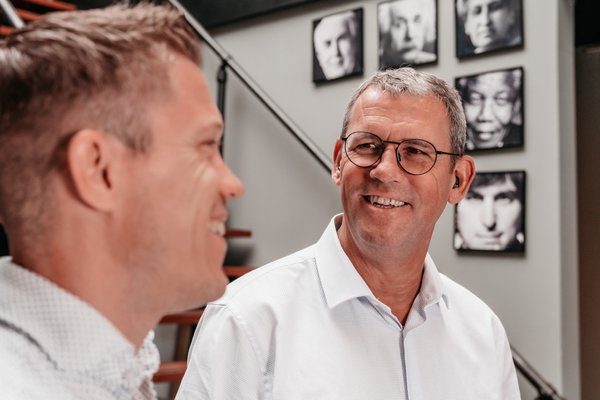 Twee collega's in gesprek bij de trap in het kantoor van Rochewood