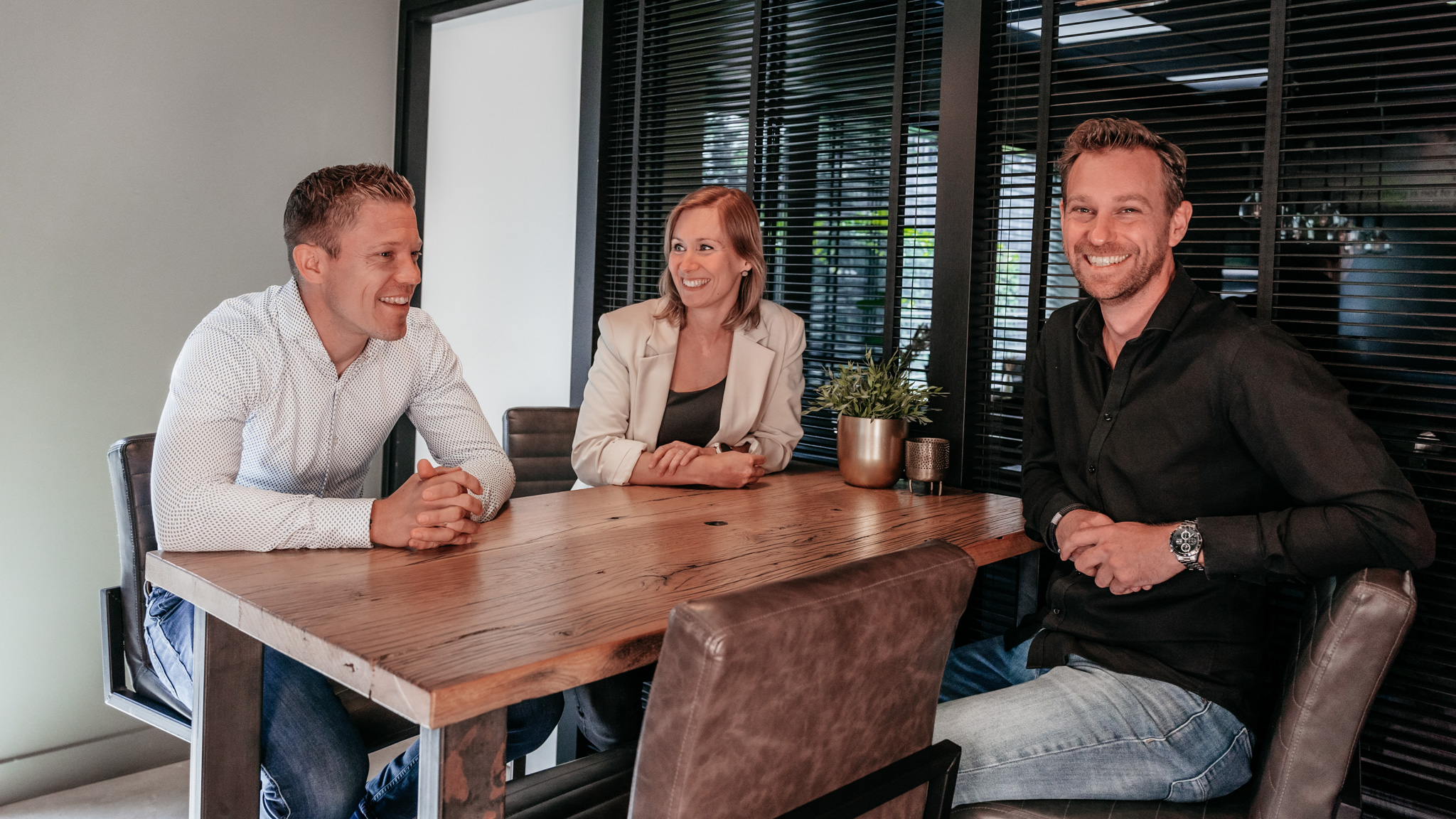 Drie collega’s van Rochewood in gesprek aan een vergadertafel